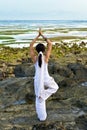 Young womang doing yoga at the beach