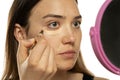 Young women applying concealer under her eyes and face Royalty Free Stock Photo