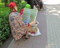 Young women artist examines painted picture