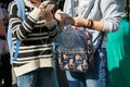 Young women with backpacks writing on smartphone in a sunny day before Trussardi fashion show, Milan Fashion