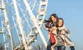 Young women best friends enjoying time together with piggyback at luna park ferris wheel Royalty Free Stock Photo
