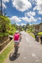 Young women is biking during rice fields cyclo tour in bali