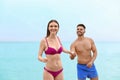 Young woman in bikini with her boyfriend on beach. Lovely couple Royalty Free Stock Photo