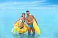 Young woman in bikini and her boyfriend with inflatable toys. Lovely couple Royalty Free Stock Photo