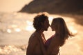 Young woman in bikini her boyfriend on beach at sunset. Lovely couple