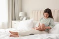 Young woman breastfeeding her little baby on bed at home Royalty Free Stock Photo