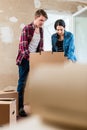 Young woman bringing open box moving in with her boyfriend into