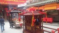 Shenzhen, China: young women burn incense and worship at the beidi temple