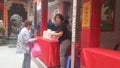 Shenzhen, China: young women burn incense and worship at the beidi temple