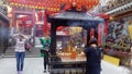 Shenzhen, China: young women burn incense and worship at the beidi temple