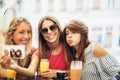 Young women in a cafe after a shopping make selfie photo Royalty Free Stock Photo