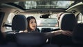 Young woman in a car,female driver looking at the passenger and smiling.Enjoying the ride,traveling,road trip concept.Driver