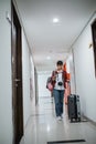 young women carrying bags and suitcases walk in the hotel hallway