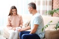 Young woman checking mature man`s pulse with medical device Royalty Free Stock Photo