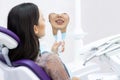 Young women checks her teeth in the mirror. Young woman in the dentists office Royalty Free Stock Photo