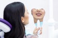 Young women checks her teeth in the mirror. Young woman in the dentists office Royalty Free Stock Photo