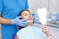 Young women checks her teeth in the mirror. Young woman in the dentists office Royalty Free Stock Photo