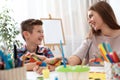 Young woman with child painted hands at table