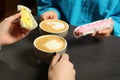 Young women with coffee and eclairs spending time together in cafe, closeup Royalty Free Stock Photo