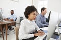 Young woman at computer with colleagues in open plan office Royalty Free Stock Photo