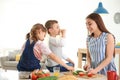 Young woman cooking breakfast for her children Royalty Free Stock Photo