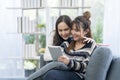 Young women couples using application on tablet. Woman enjoying time relaxing on sofa