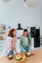 Two girlfriends cut fruit in the kitchen Royalty Free Stock Photo