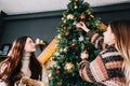 Young women decorates the Christmas tree with toys. Preparing for the holidays Royalty Free Stock Photo