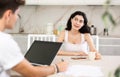 Young woman discussing deal with salesman in kitchen