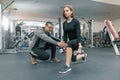 Young woman doing exercises with personal instructor in gym. Sport, athlete, training, healthy lifestyle and people concept Royalty Free Stock Photo