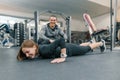 Young woman doing exercises with personal instructor in gym. Sport, athlete, training, healthy lifestyle and people concept Royalty Free Stock Photo