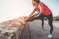 Young woman doing stretching with personal trainer - Fit people training at sunset outdoor - Focus on woman body - Fitness,