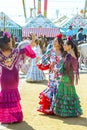 Young women dressed in colourful dresses at the Seville April Fair in Spain