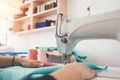 Young woman dressmaker sews clothes on a sewing machine in creative studio. Close-up photo of female hands and clo Royalty Free Stock Photo