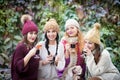Young women drink mulled wine in autumn park. Sunny autumn day. Outdoors lifestyle fashion portrait