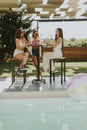 Young women drinking coctail and having fun by the swimming pool Royalty Free Stock Photo