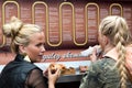 Young women eating hot dogs outdoors