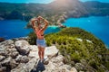 Young women enjoying view to Assos village Kefalonia from top castle. Beautiful blue colored bay lagoon underneath Royalty Free Stock Photo