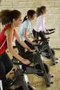 Young women on exercise bikes