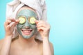 Young women with facial masks and cucumber slices isolated over studio blue wall Royalty Free Stock Photo