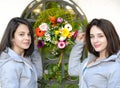 Young women facing each other with flowers between them