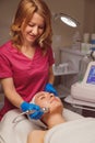 Young woman getting microcurrents skin cleansing and face treatment at beauty salon