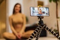 Young women girl fitness instructor blogger influencer recording video blog concept speaking looking at smartphone on tripod Royalty Free Stock Photo