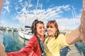Young women girlfriends taking summer selfie at harbour docks