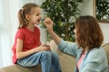 Young woman giving pill to her daughter at home