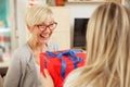 Happy senior woman receiving gift box from daughter Royalty Free Stock Photo