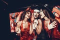 Young Women in Halloween Costumes Singing Karaoke Royalty Free Stock Photo