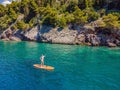 Young women Having Fun Stand Up Paddling in blue water sea in Montenegro. SUP. girl Training on Paddle Board near the Royalty Free Stock Photo