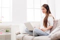 Young women in headphones listening to music and using laptop Royalty Free Stock Photo