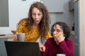 Young woman helps senior on laptop computer